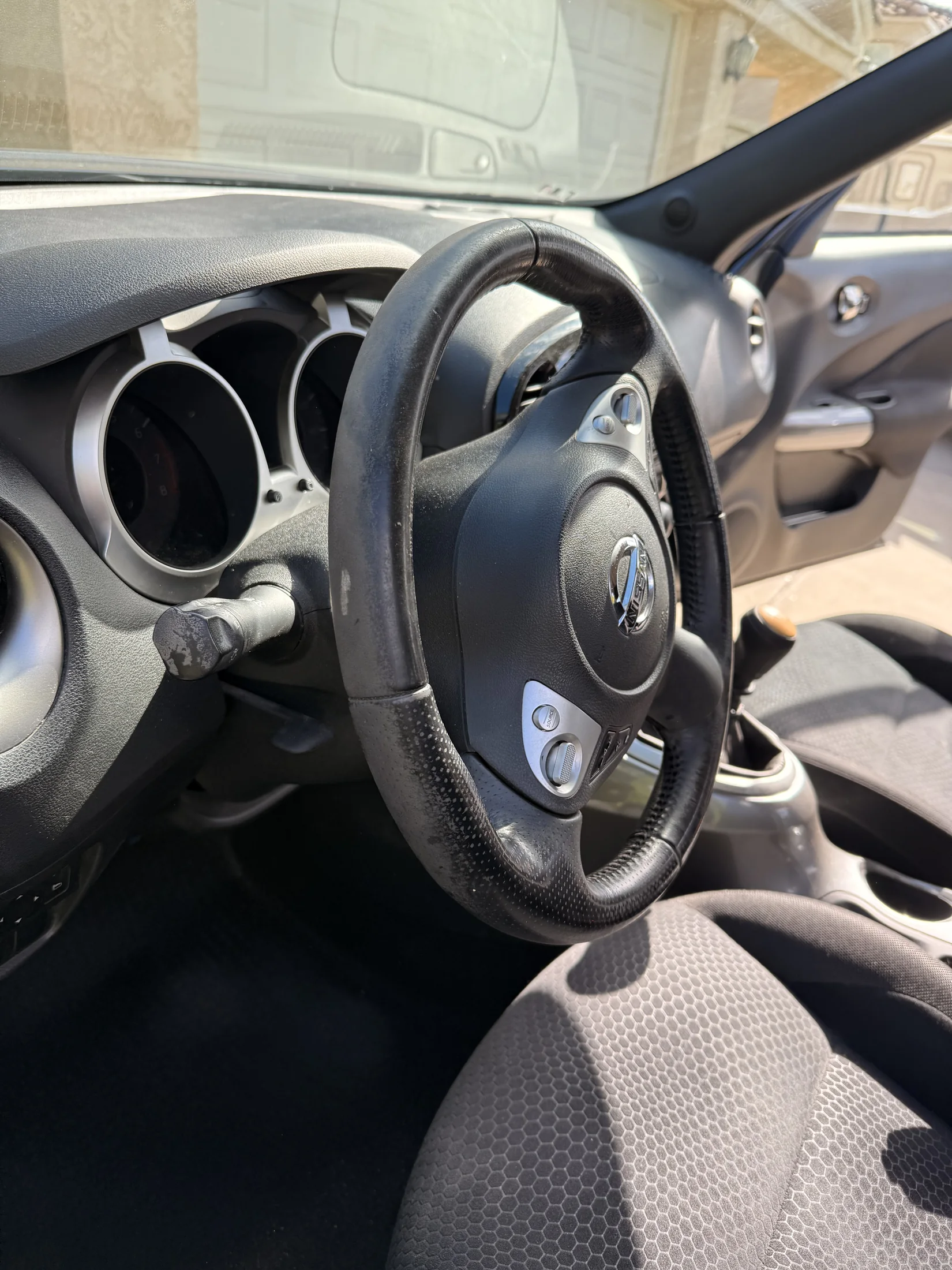 Nissan steering wheel and driver area before interior detailing